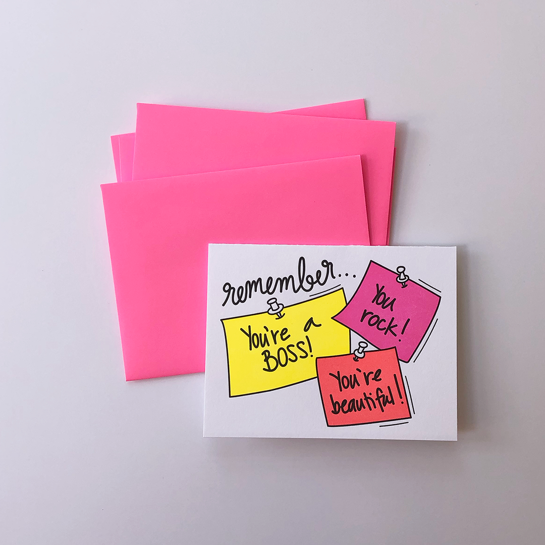 An flat lay shot of a greeting card over three envelopes. The Greeting Card has an image of three sticky notes with the words You're a Boss, You Rock and You're Beautiful.