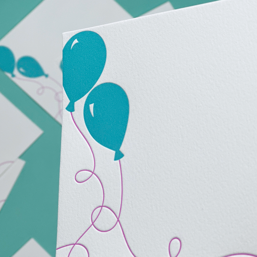 A close-up of a notecard with balloons printed on cotton paper. 