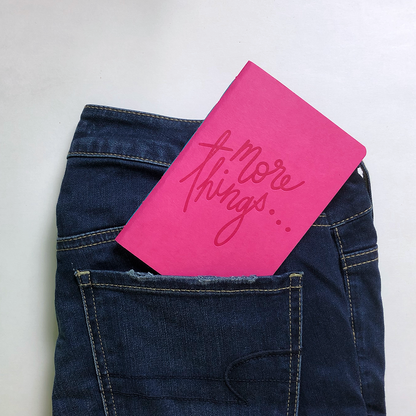 A pair of jeans with an Add Pink and Stir pink letterpress pocket notebook